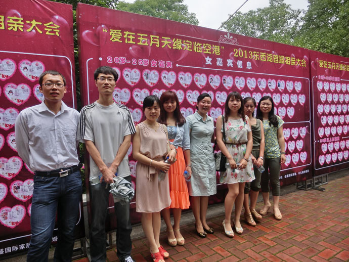"为明相亲团"领队涂娟与部分队员在嘉宾信息墙前合影